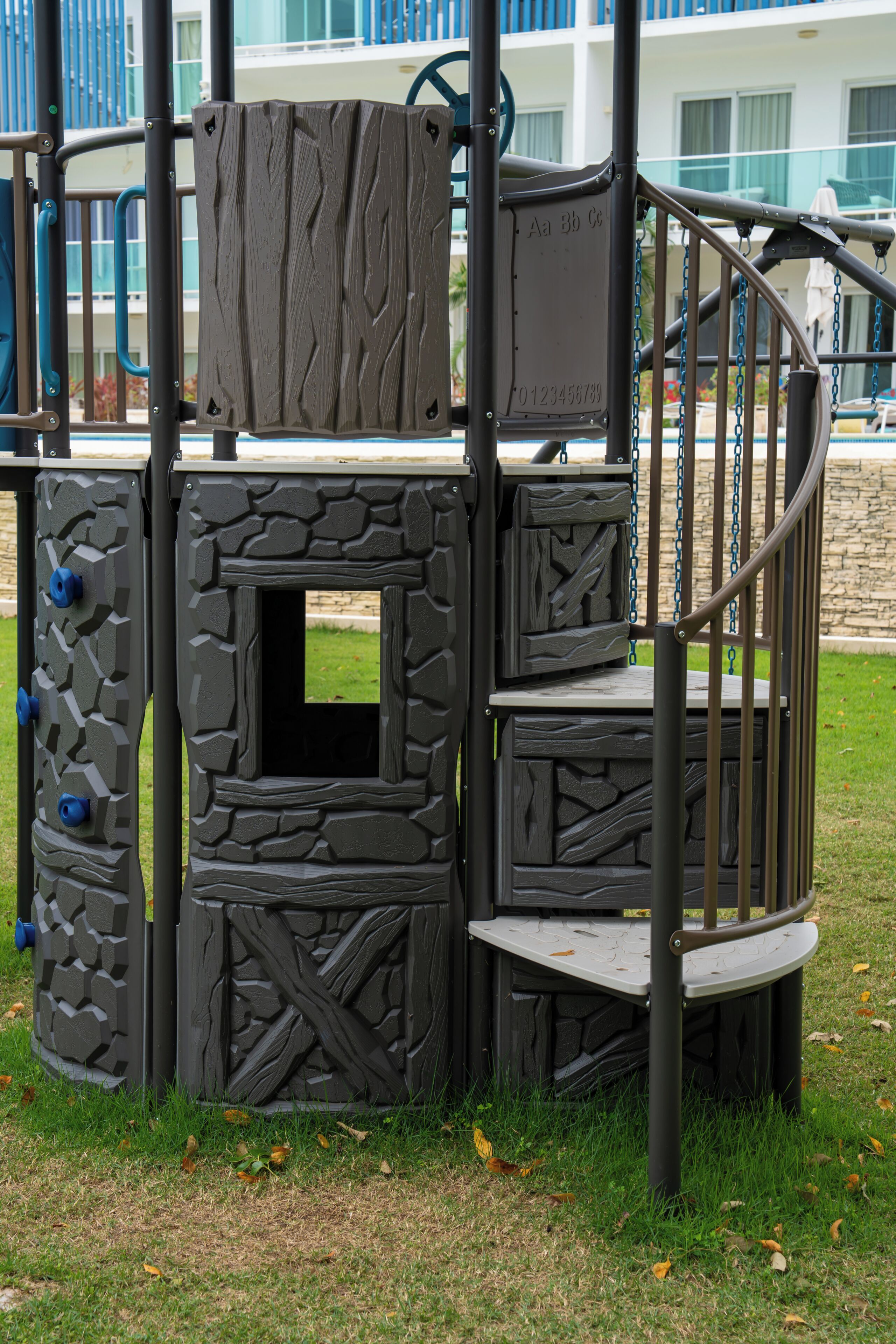 A play structure with climbing elements and a spiral slide.
