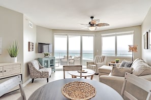 Enjoy ocean views from the spacious living area with a dining table, sofas, and armchairs.