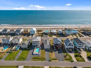 A coastal residential area with houses, a swimming pool, and a beach in the background. - Heart of Oak Island/2nd Row Ocean Vew - 3 Bedrooms (Oak Island)