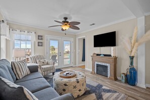 TV connectée, cheminée, table de tennis de table, livres