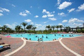 A large outdoor swimming pool with palm trees and a clear blue sky. - 4012 Vista Cay (Orlando)