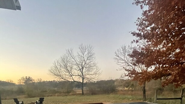 A hot tub with a view of a grassy field and trees in the background. - Moonlight on the White- Fayetteville river cabin (Springdale)