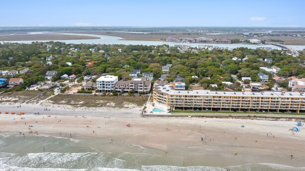 Ein Hotel an der Küste mit mehreren Etagen, einem Pool und Blick auf den Strand.