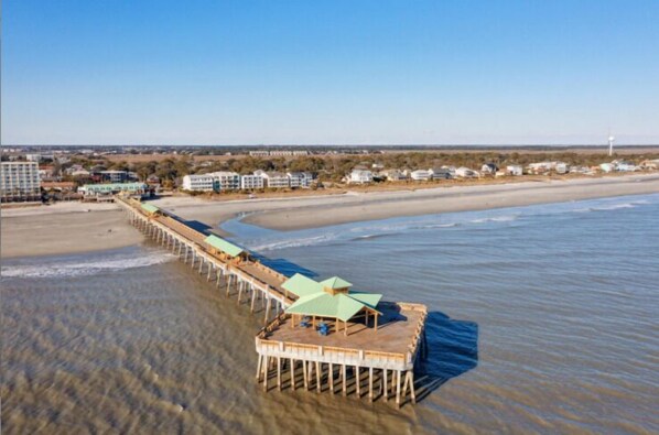 A pier extending into the water with a building at the end.