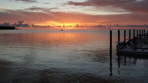 A marina with boats docked, calm water, and a sunset in the background. - Keys Villa--Islamorada private beach! (Islamorada)