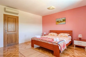 Une chambre à coucher avec un lit en bois, une table de chevet, une lampe et un tableau au mur.