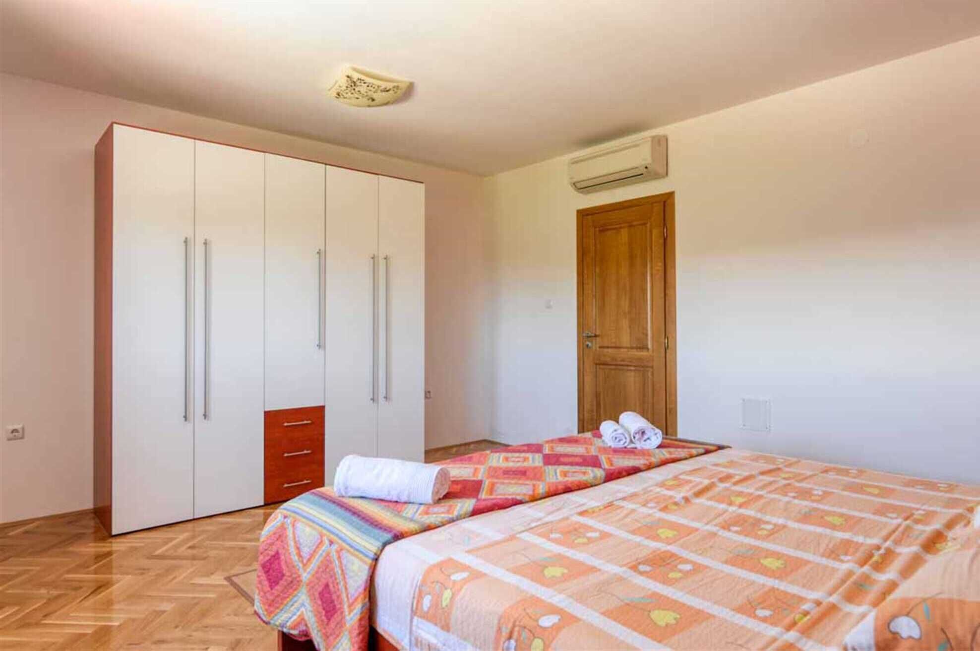 A bedroom with a bed, a wardrobe, and a wooden door.