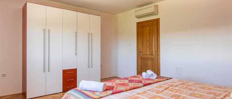 A bedroom with a bed, a wardrobe, and a wooden door.