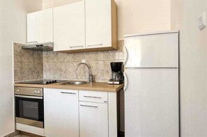 Kitchen features an oven, dishwasher, and coffee maker, along with a double-door refrigerator and modern sink.