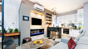 Una sala de estar moderna con chimenea, comedor y cocina.