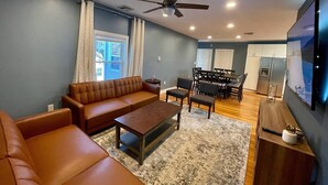 A modern living room with a sofa, coffee table, and dining area. - MODERN MASSIVE LARGE GROUP 3800sf MIT HARVARD BOS (Somerville)