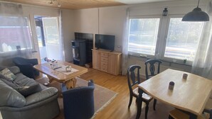 Een moderne woonkamer met een bank, een salontafel, een eettafel en een televisie.