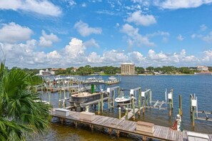 A marina with docked boats, a wooden pier, and a building in the background.