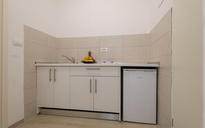 Enjoy cooking in this well-equipped kitchen with a refrigerator, sink, and ample countertop space.