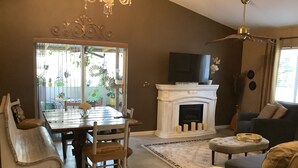 Un salon avec une cheminée, une table à manger et un canapé.