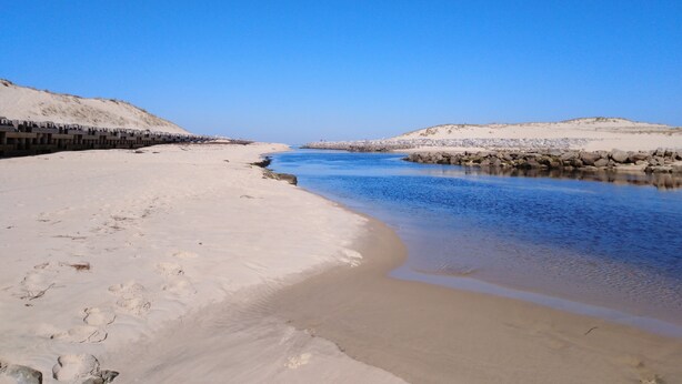 A sandy beach with a calm river, clear skies, and rocky outcrops. - Cottage T2 (Lit-et-Mixe)