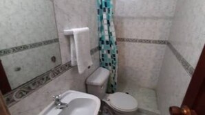 A small bathroom with a toilet, sink, and shower. - 3G1-2 APARTAMENTO EN CARTAGENA (Cartagena)