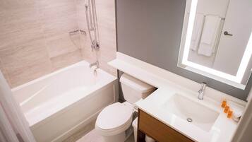 Bathtub, hair dryer, towels, shampoo