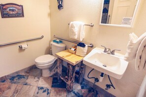 A bathroom with a toilet, sink, and a towel rack.