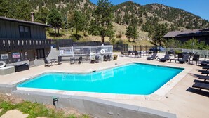 Una piscina amb gandules i vistes a un paisatge de muntanya.