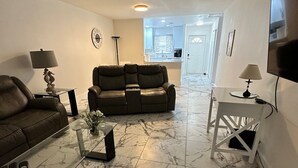 A living room with a sofa, a coffee table, a TV, and a ceiling fan. - 2/2 Duplex on CANAL all updated; new furniture, (Rotonda West)
