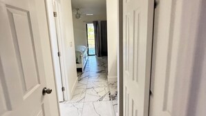 A hallway with white doors, marble flooring, and a ceiling fan. - 2/2 Duplex on CANAL all updated; new furniture, (Rotonda West)