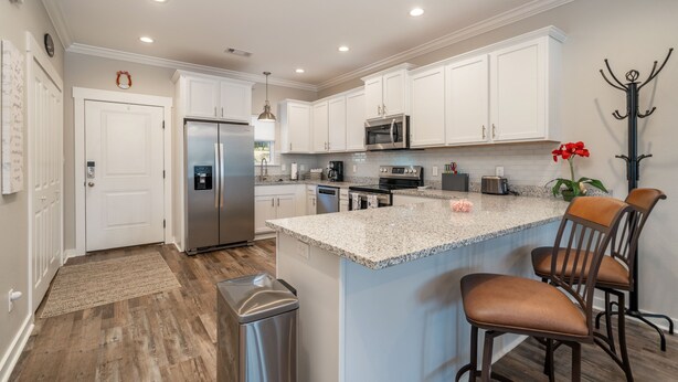 A modern kitchen with white cabinets, stainless steel appliances, and a granite countertop. - The Lookout - Lake Views, Swim, Fish, & More! (Hot Springs)