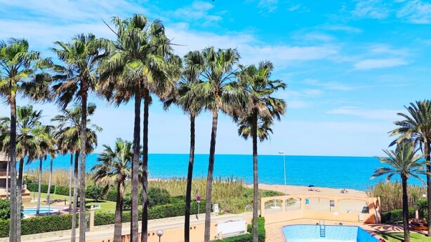 Ein Resort mit Palmen, einem Pool und Blick auf das Meer.