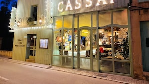 En byggnad med en skylt som visar texten ”CASSAI” och en annan skylt som anger att det är ett ”LYXIGT CAFÉ OCH RESTAURANG”.