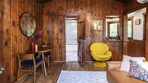 Een houten interieur met een houten stoel, een tafel en een bank.