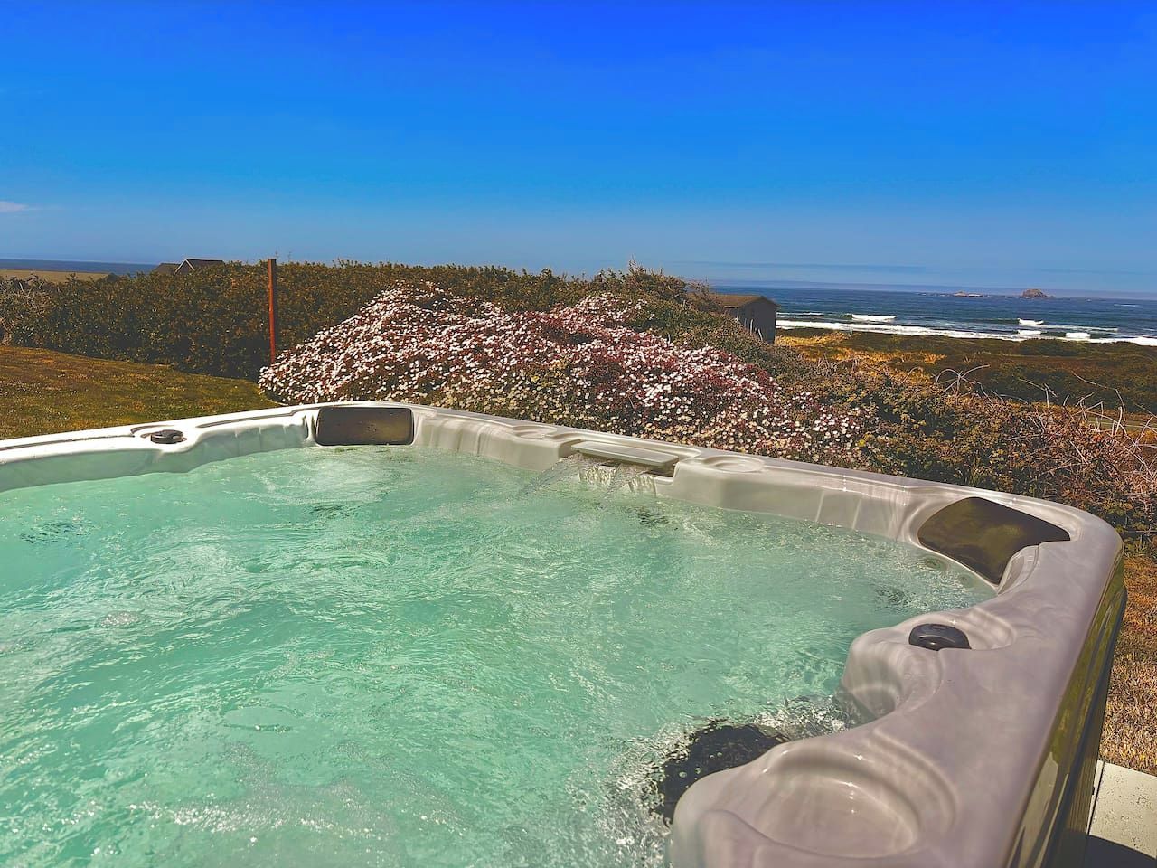 Un jacuzzi con vistas despejadas al océano y una isla lejana.