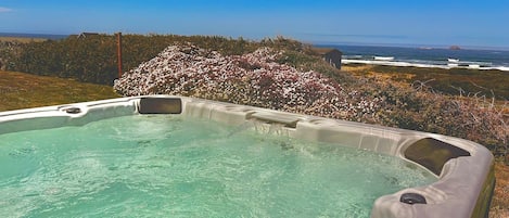 Un jacuzzi con vistas despejadas al océano y una isla lejana.
