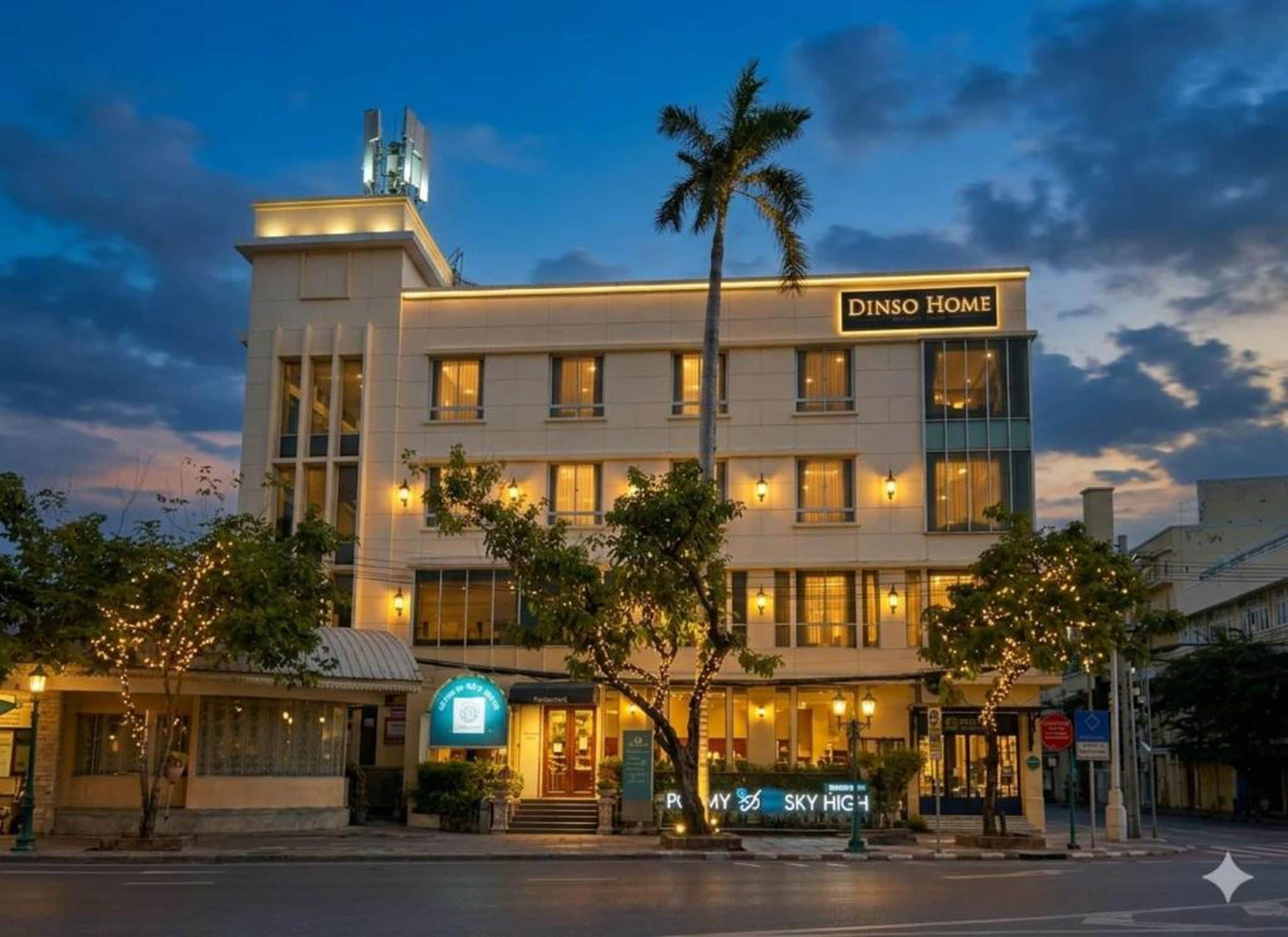 A hotel named DINSO HOME with a modern facade, multiple windows, and a sign indicating a restaurant on the ground floor.