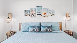 A bed with a quilted blue blanket, two matching pillows, and a headboard.