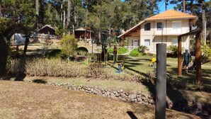 Un quartier résidentiel comprenant une maison, des équipements de musculation en plein air et un petit chalet.