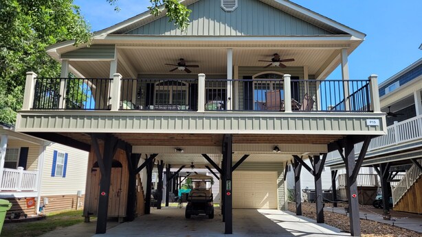 A two-story house with a balcony, a garage, and a covered driveway.