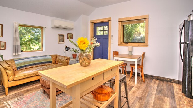 Una sala de estar acogedora con una mesa de madera, un sofá y un comedor.