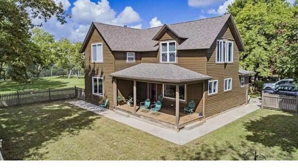 A two-story house with a covered porch and a fenced backyard. - Flinthills Premier Getaway (Severy)