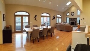 A spacious living area with a dining table, sofas, and a fireplace. - EAT, DRINK, PLAY & RELAX in Windham (Windham)
