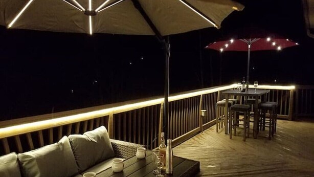 An outdoor deck with a sofa, dining table, and umbrellas. - EAT, DRINK, PLAY & RELAX in Windham (Windham)