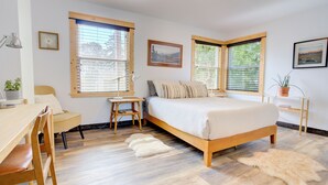 A bedroom with a bed, two windows, a desk, a chair, and a small table. - Lovely Spacious Home In Downtown White Salmon (White Salmon)
