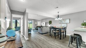 A spacious living area with a dining table, chairs, and a kitchen in the background. - 3 Pools, Year Round Indoor pool and Hot tub, Gorgeous and Fun/10th Tee, WALK IN (Branson)
