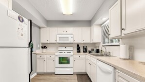 A modern kitchen with white cabinets, a microwave, stove, and a dishwasher. - 3 Pools, Year Round Indoor pool and Hot tub, Gorgeous and Fun/10th Tee, WALK IN (Branson)