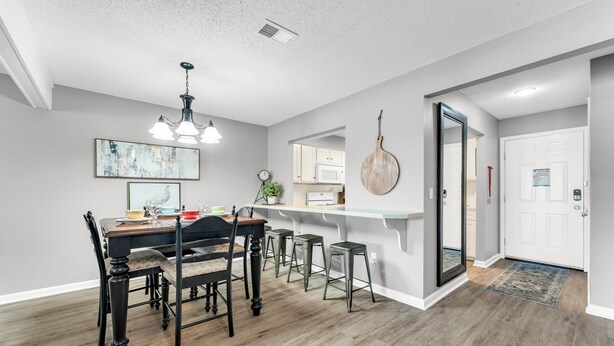 A modern kitchen with a dining area, wooden flooring, and a large island. - 3 Pools, Year Round Indoor pool and Hot tub, Gorgeous and Fun/10th Tee, WALK IN (Branson)