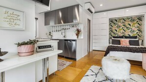 A modern apartment with a kitchenette, a dining area, and a bedroom. - Not so tiny house with full kitchen & patio swing (Pittsburgh)