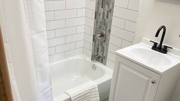 Bañera con ducha, secador de pelo, toallas, jabón
