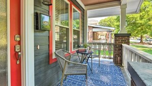 A porch with a blue patterned floor, a metal chair, and a small table with a potted plant. - NEW! Centrally Located Charlotte Home by Amtrak! (Charlotte)