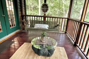 A wooden deck with a bench and a decorative planter. - Creekfront Cabin with Waterfall, Hot Tub, Fire Pit (Ellijay)