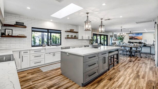 A modern kitchen with white cabinetry, a large island, and pendant lighting. - Spacious Modern Oasis with Pool, Hot Tub, and Putting in Scottsdale (Phoenix)