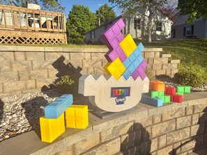Uma exposição ao ar livre com tema Tetris, com blocos coloridos e um letreiro Tetris.